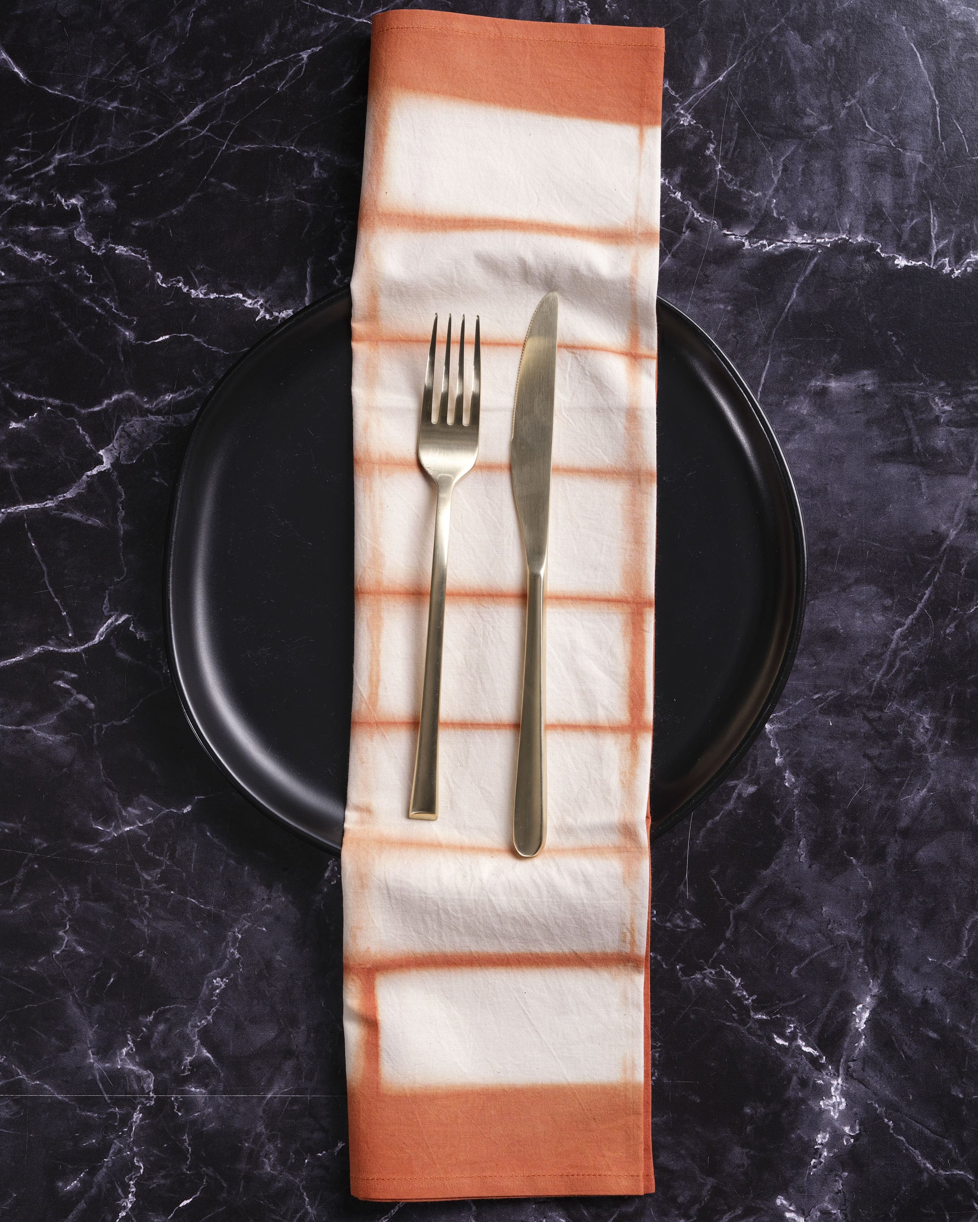 Hand-dyed Shibori cotton napkin with amber rectangle pattern for dining table