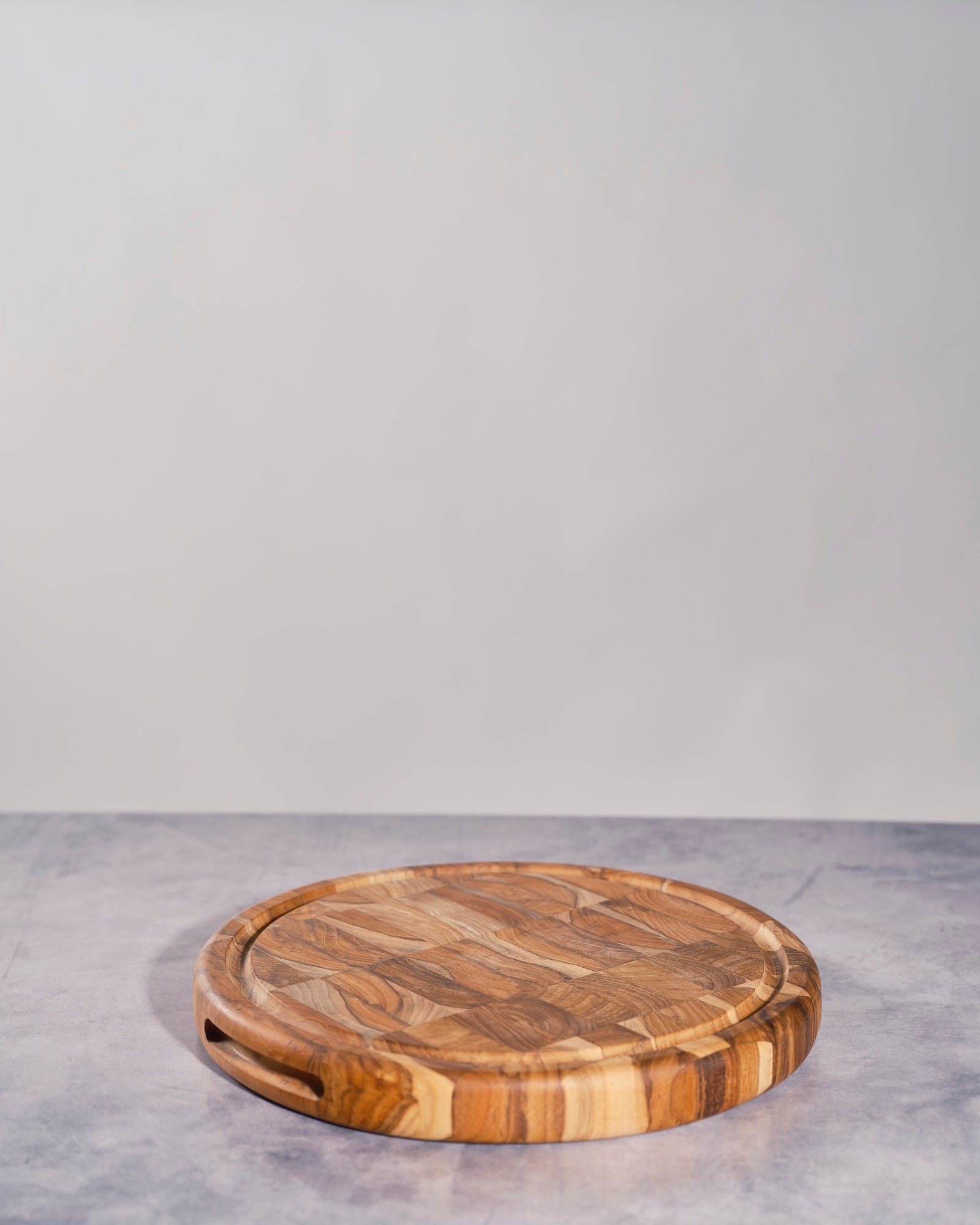 Handcrafted round teakwood mosaic serving board with natural wooden pattern